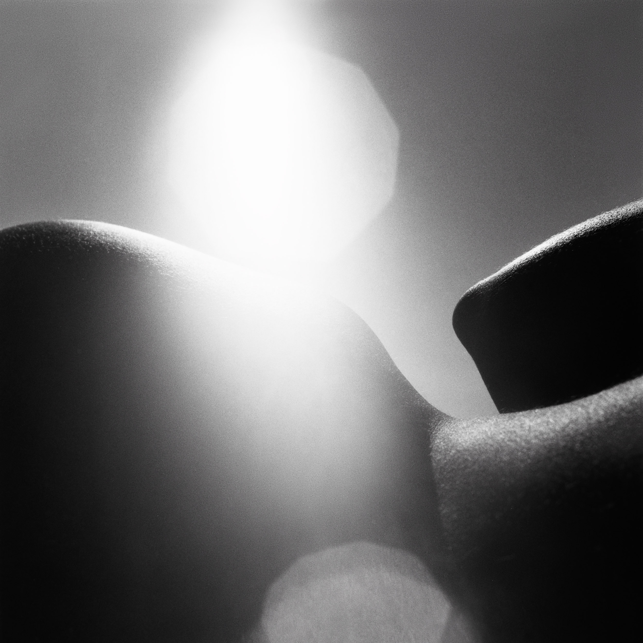 close up of a woman's hips, laying down on a beach, from the series a simple life by Emmanuel Pineau