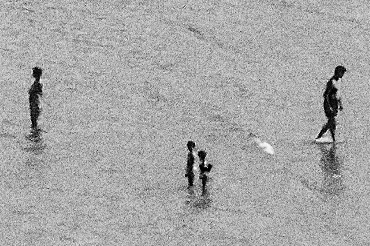 The blurred silhouettes of people by the sea in Brittany in the summer, from the series Another summer by Emmanuel Pineau