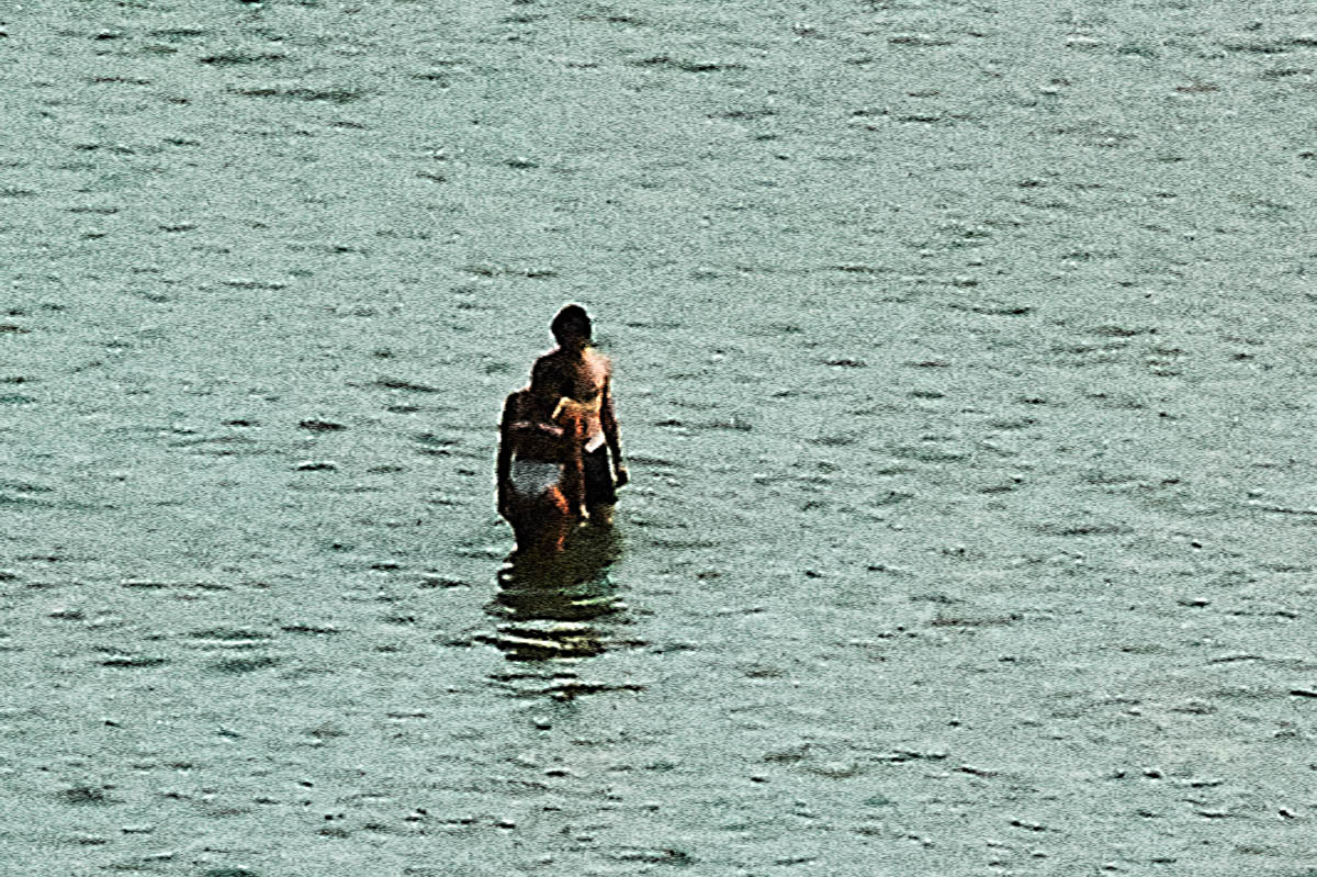 The blurred silhouettes of a couple in the sea in Brittany in the summer, from the series Another summer by Emmanuel Pineau
