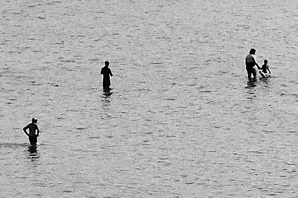 Blurry silhouettes of people in the water on a beach in Brittany in the summer, from the series Another summer by Emmanuel Pineau