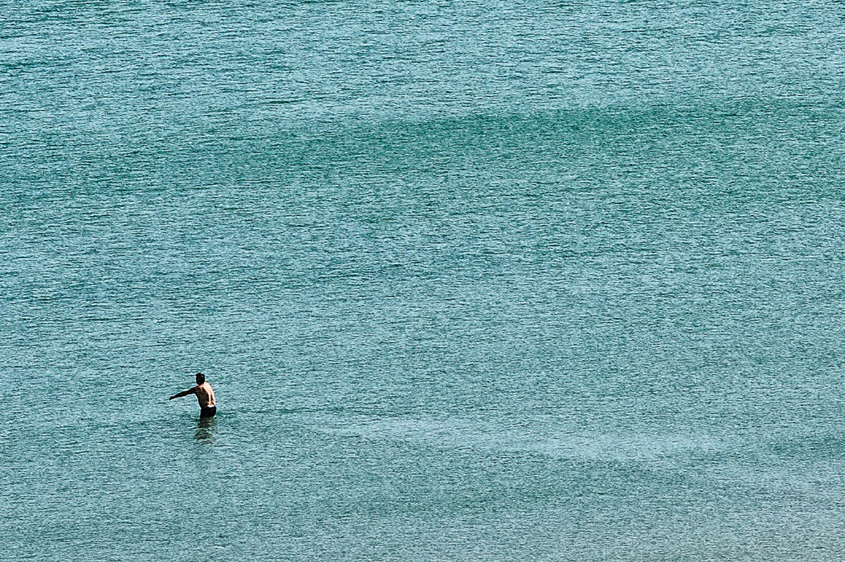 The blurred silhouette of a man about to enter the water on a beach in Brittany in summer, from the series Another summer by Emmanuel Pineau