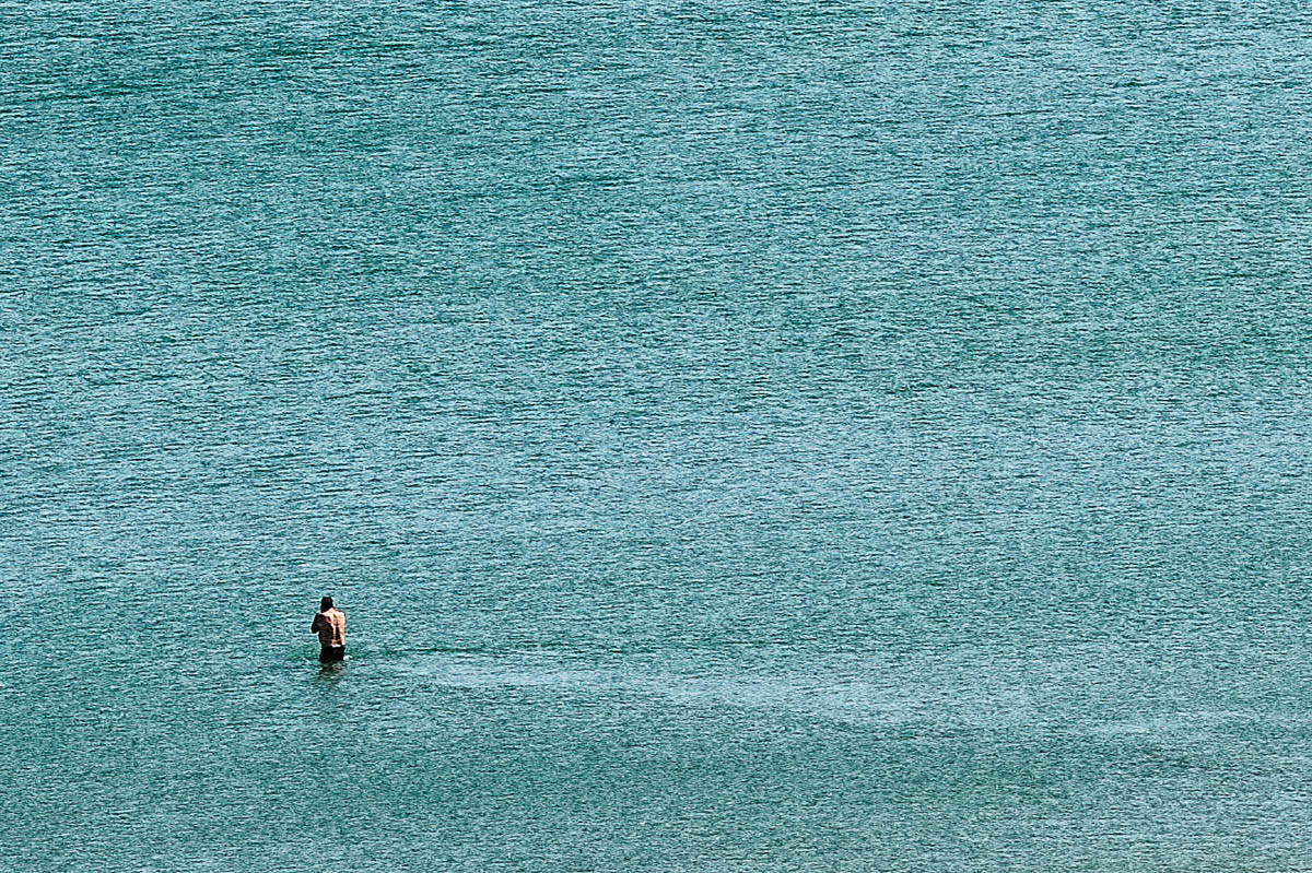 The blurred silhouette of a man about to enter the water on a beach in Brittany in summer, from the series Another summer by Emmanuel Pineau