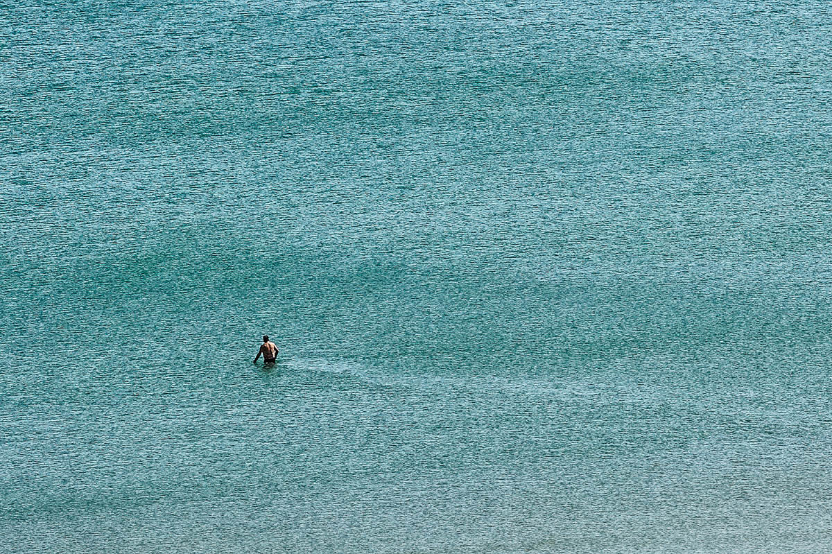 The blurred silhouette of a man walking into the sea on a beach in Brittany in summer, from the series Another summer by Emmanuel Pineau
