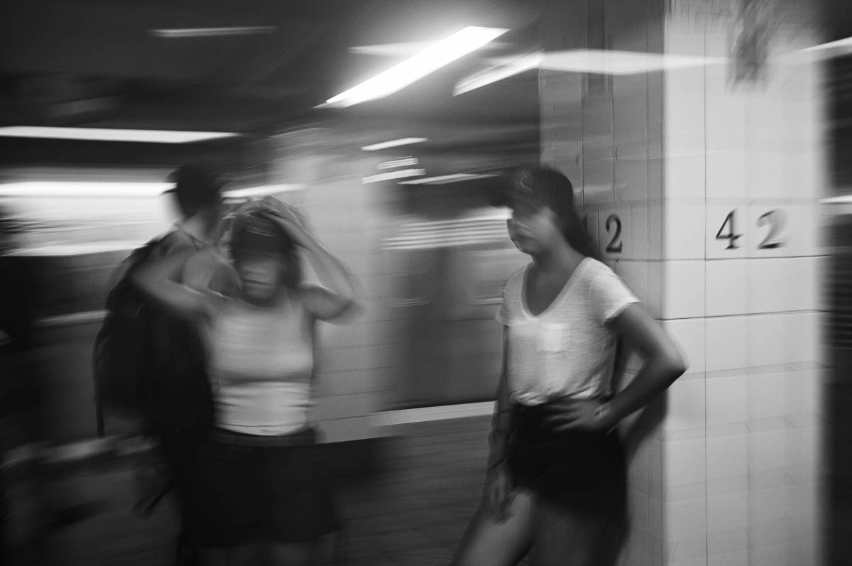Two young women are waiting for the subway at the 42nd Street station in New York, from the series Going Underground by Emmanuel Pineau