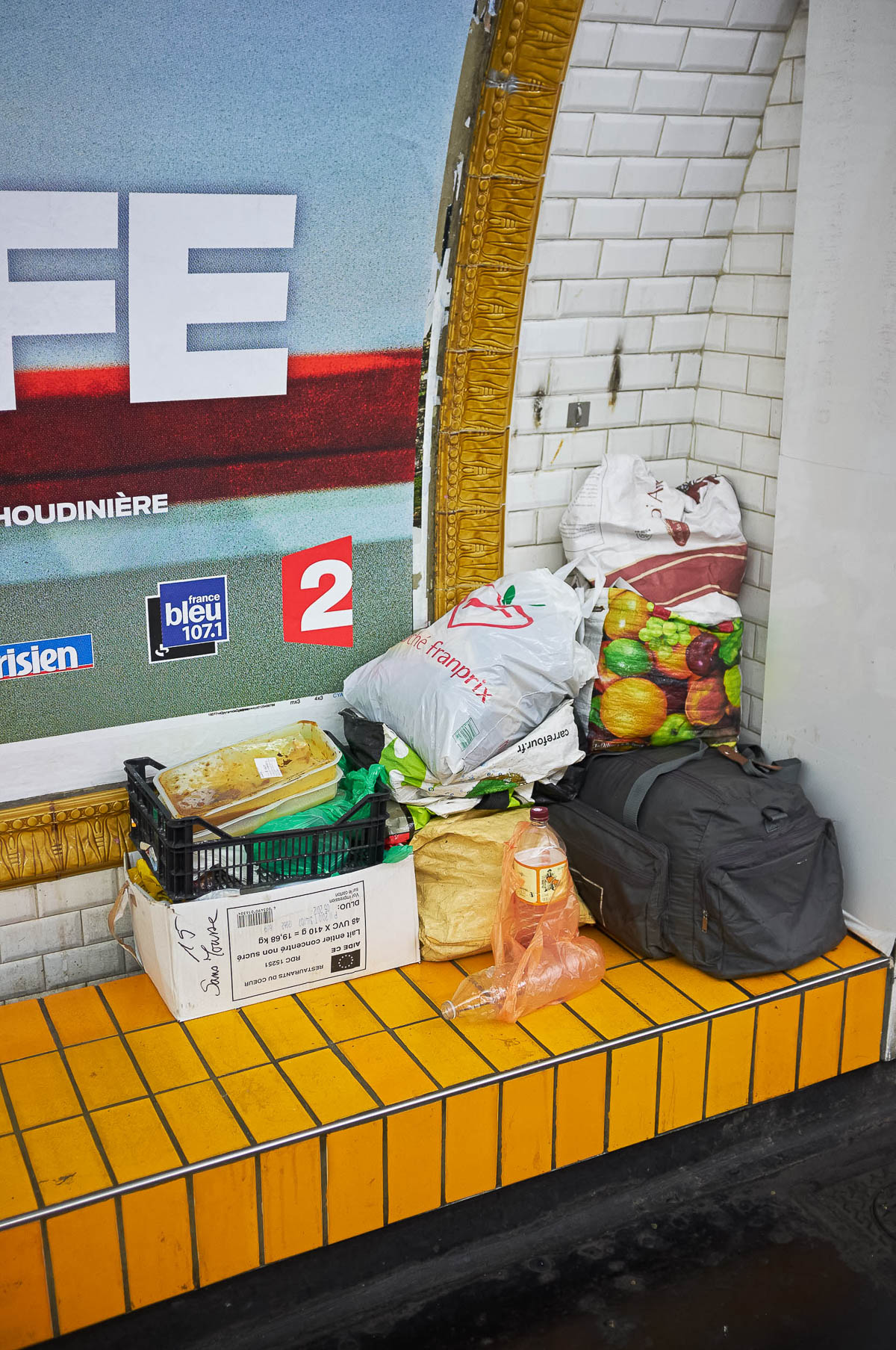 A homeless man's luggage piled up on a subway platform in Paris, from the series Going Underground by Emmanuel Pineau