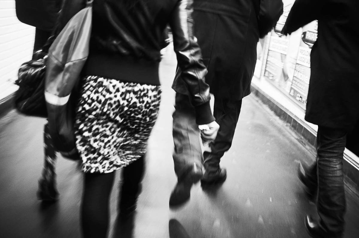 A woman seen from behind, wearing a short leopard-print skirt, walks through the corridors of the Paris metro, from the series Going Underground by Emmanuel Pineau