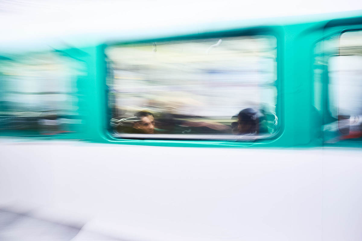The blurred face of a man sitting in a moving subway car, from the series Going Underground by Emmanuel Pineau