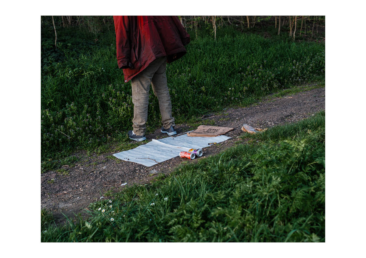 A homeless man wearing a red jacket in a park in Montreuil, from the series I will be around by Emmanuel Pineau