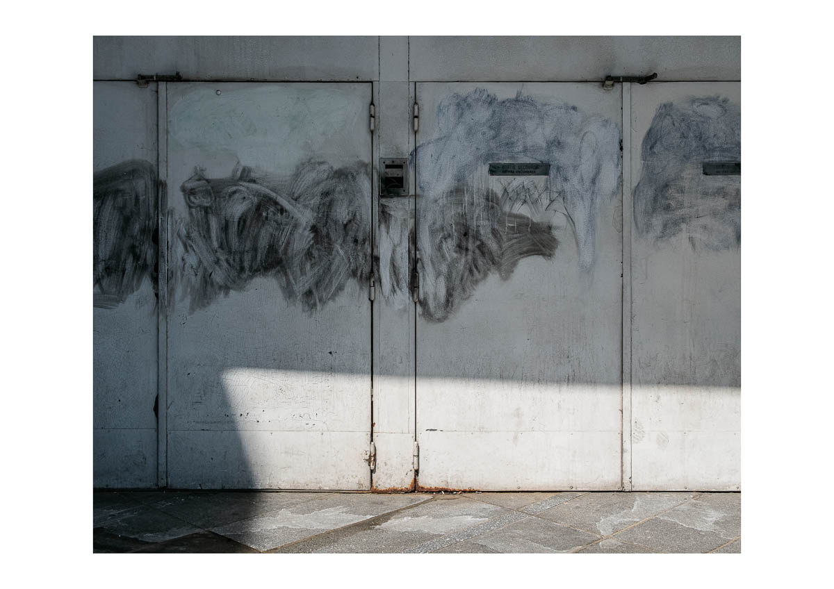 A half-erased piece of graffiti on a wall at the gate of Montreuil, from the series I will be around by Emmanuel Pineau