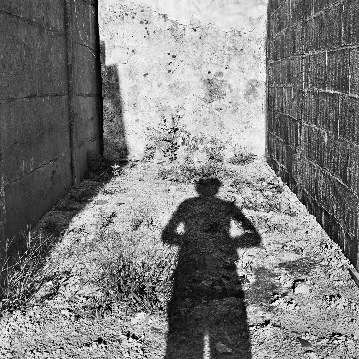 The photographer's shadow facing a wall, from the series Les limites du territoire by Emmanuel Pineau