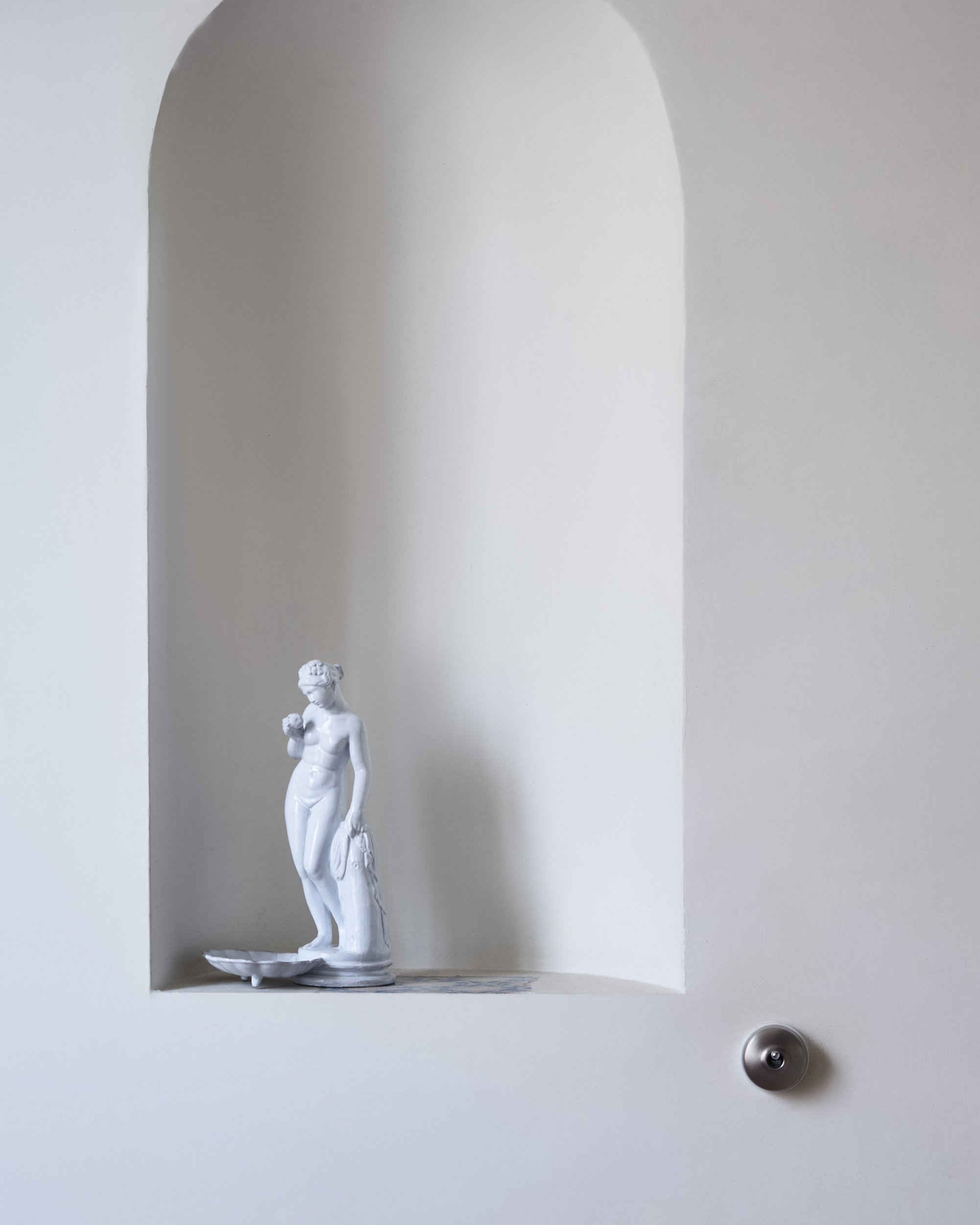 White ceramic bather by Astier de Villatte in a niche, still life photography by Emmanuel Pineau