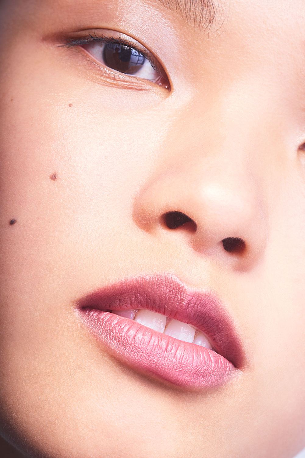 Close up of an Asian model's face with natural skin texture by Sophie Delaporte