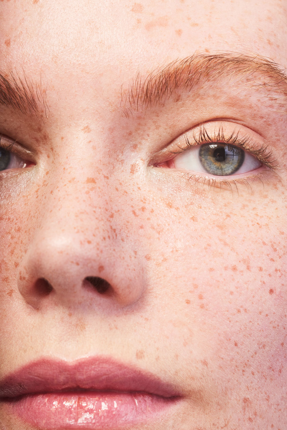 Close up of a Caucasian model's face with natural skin texture and freckles by Sophie Delaporte