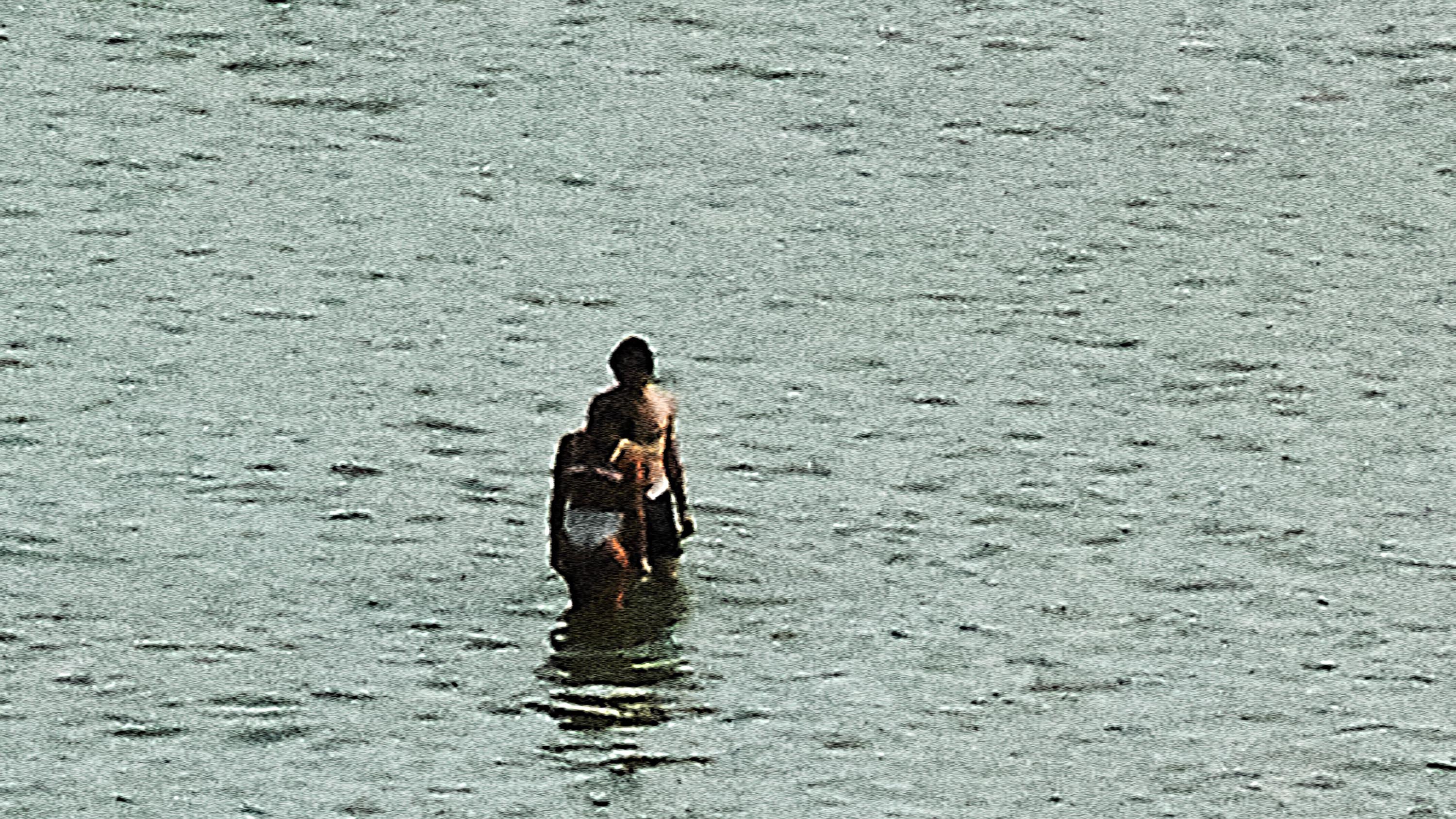 A couple walking in the sea during the summer in Brittany, from the series Another summer, by Emmanuel Pineau