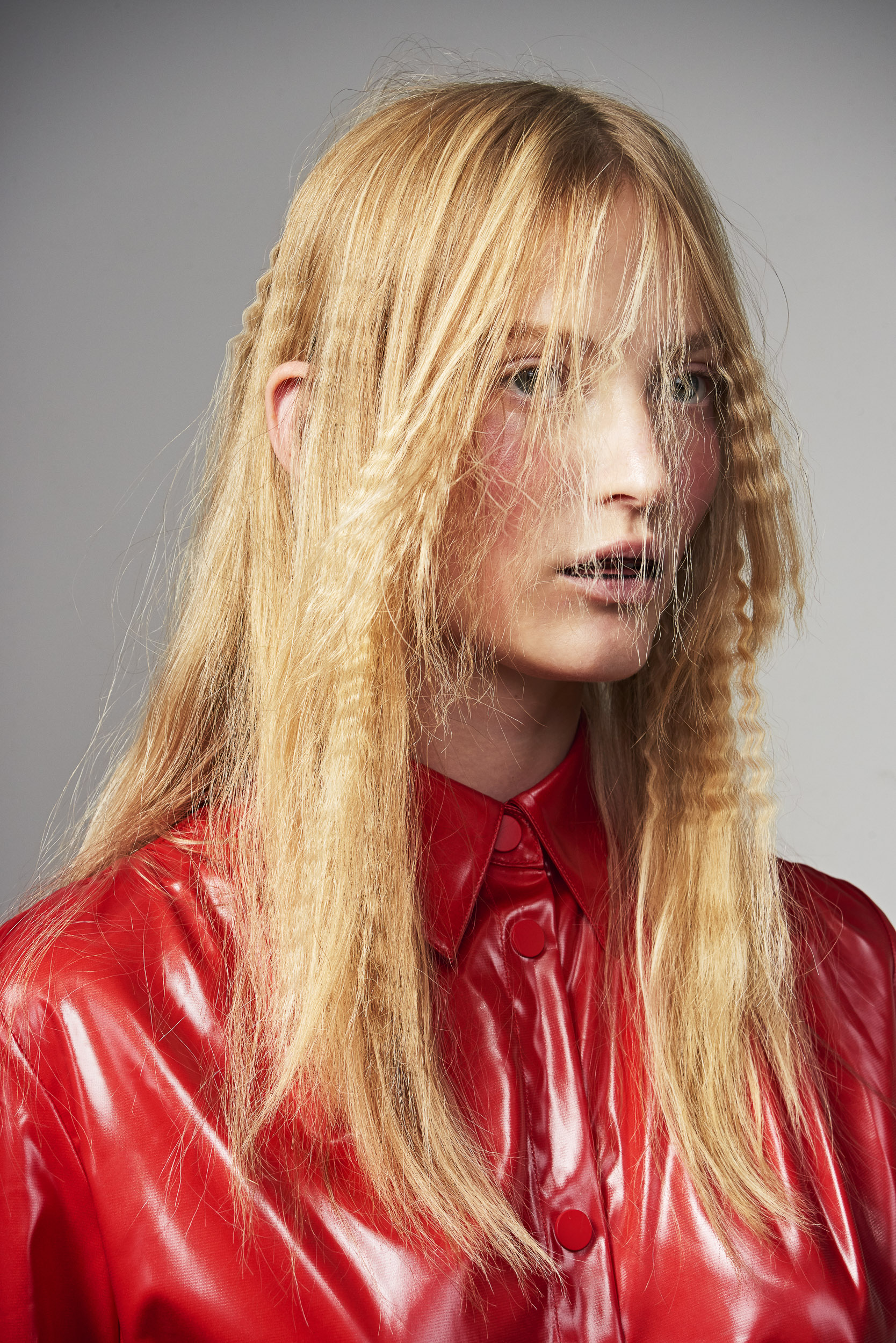 Blond model wearing a red raincoat, photography by Sophie Delaporte