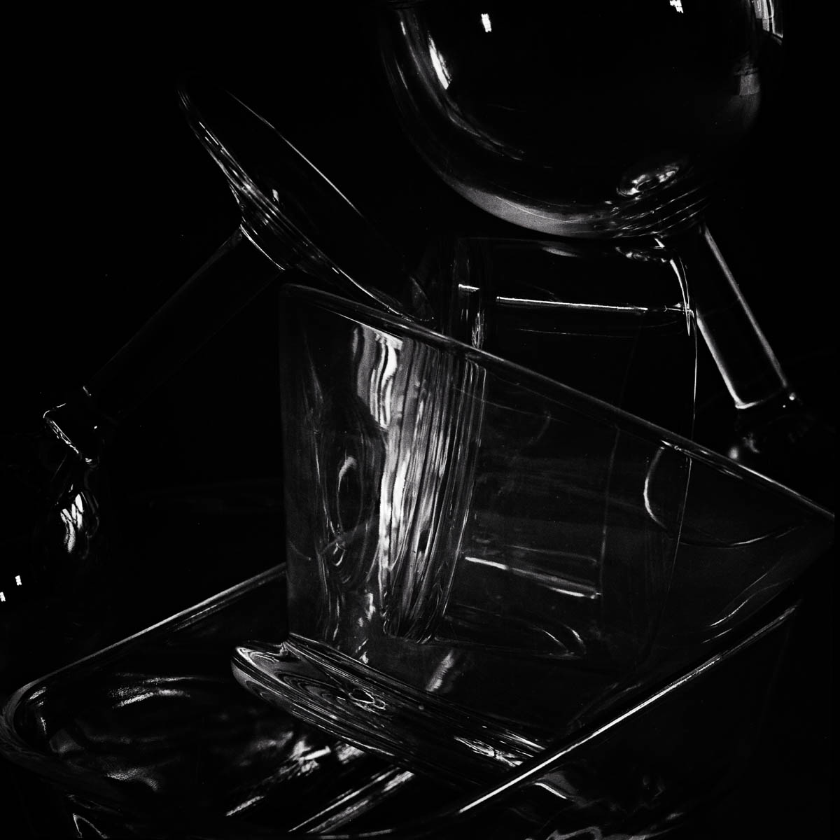 Still life with glass objects stacked on a dark background, from the series One piece of my mind by Emmanuel Pineau