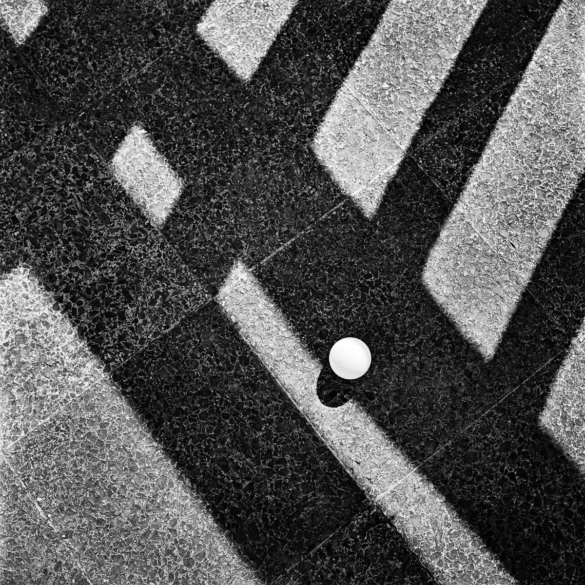 A small ball, forgotten on a terrace in the shadows of the balustrade, from the series One piece of my mind by Emmanuel Pineau