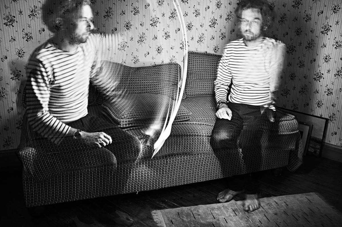 Double self-portrait of Emmanuel Pineau sitting on a vintage sofa with light painting effects, from the series Out of disorders by Emmanuel Pineau