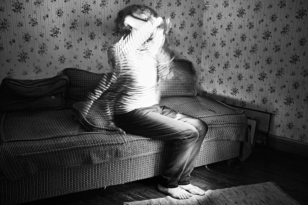 Self-portrait of Emmanuel Pineau sitting on a vintage sofa with light painting effect, from the series Out of disorders by Emmanuel Pineau